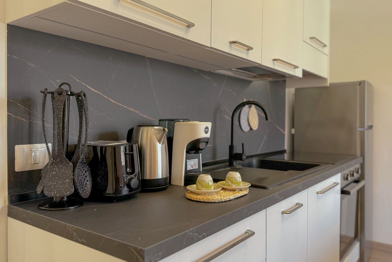 Una cucina con rivestimento in marmo, elettrodomestici in acciaio inossidabile e un design moderno.