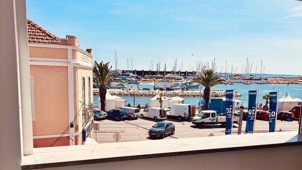 A marina with parked cars and boats, a clear sky, and a building with a tiled roof. - 7 Night Discount- Lagos Marina- Doublebed (Lagos)