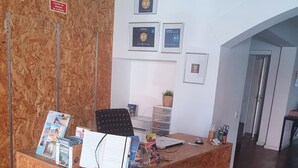A reception desk with a corkboard, framed certificates, and a potted plant. - 7 Night Discount- Lagos Marina- Doublebed (Lagos)