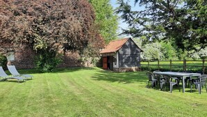 A grassy outdoor area with a small building, a table with chairs, and two sun loungers. - Le Clos Saint Martin, charming gîte - 14 pers- Chic countryside 35mn from the sea (Cavron Saint Martin)