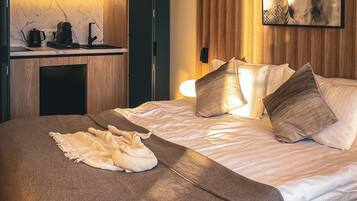 A modern bedroom with a bed, bedside table, and a wall-mounted artwork.