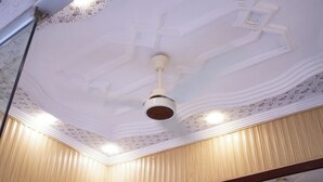 A ceiling with a central fan, decorative molding, and recessed lighting. - Al Amarat Hotel Tariq Road (Karachi)