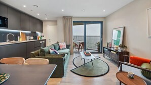 Eine moderne Wohnung mit Küche, Wohnbereich und Balkon.