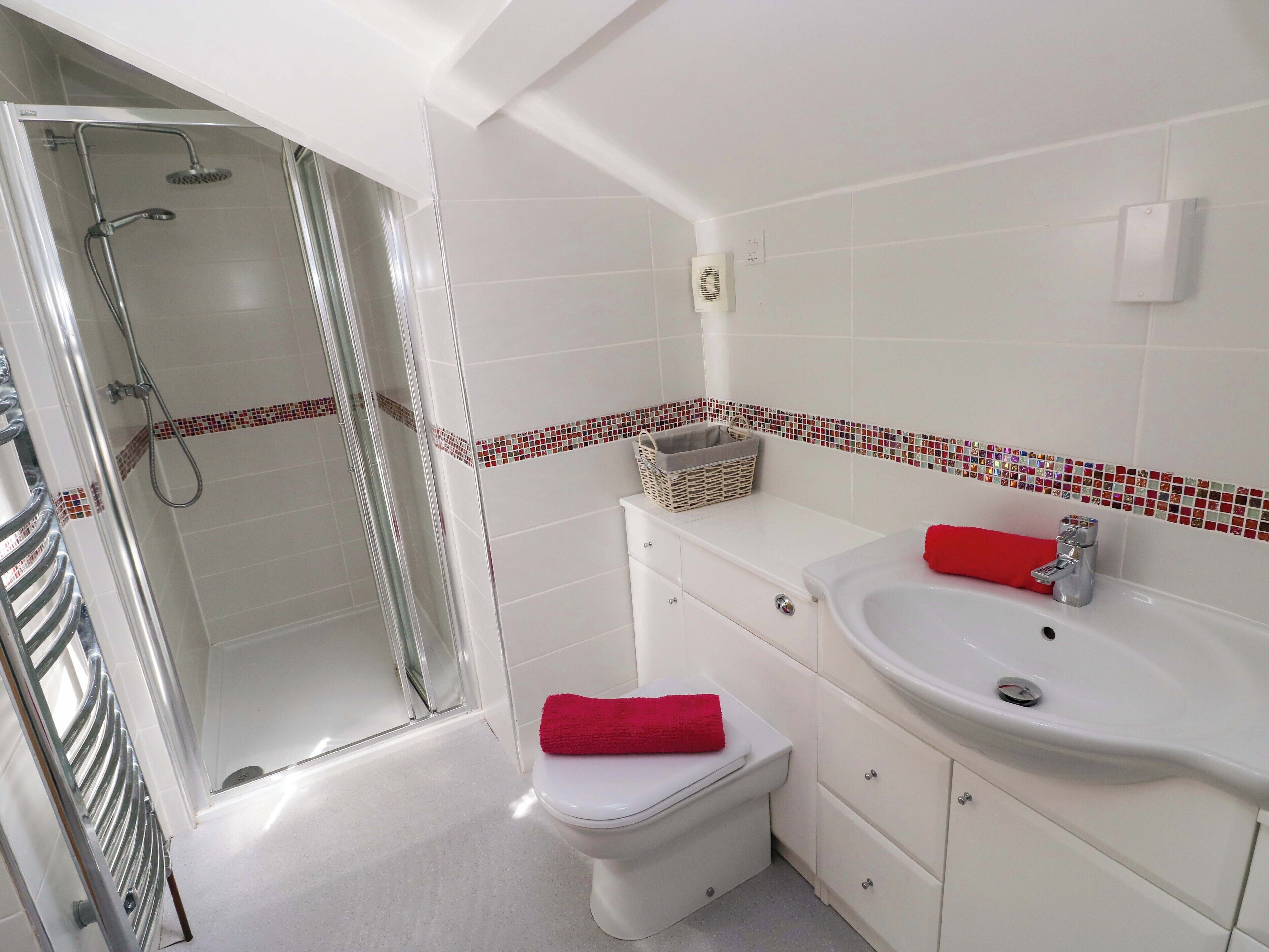 A bathroom with a shower, toilet, and sink.