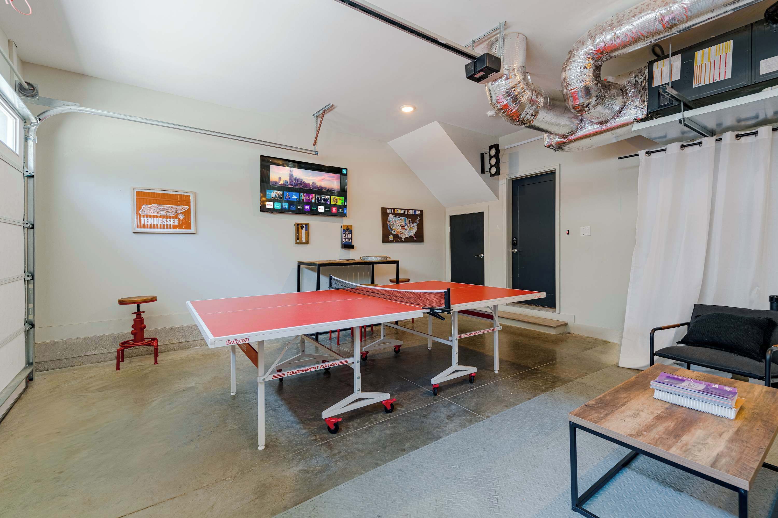 A ping pong table in a room with a TV, a map, and a door marked with the number 18.