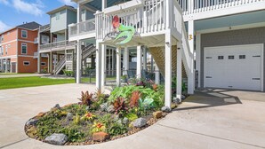 Un immeuble résidentiel à plusieurs étages doté d’un balcon, d’un garage et d’un jardin aménagé.