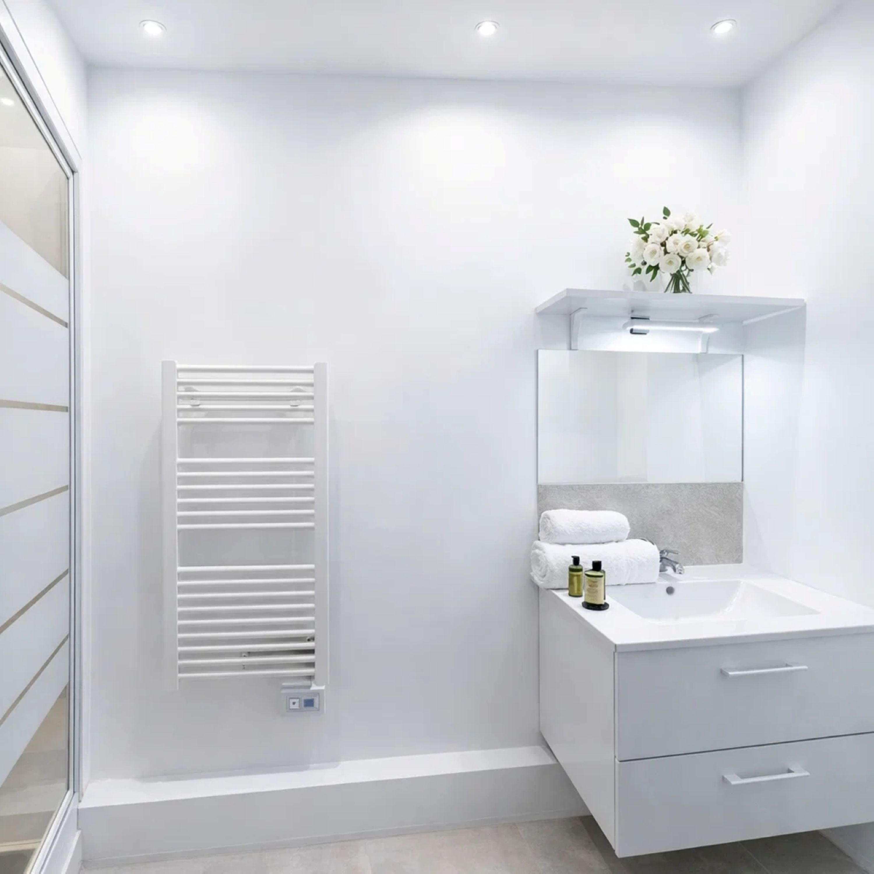 A modern bathroom with a white sink, mirror, and towel rack.
