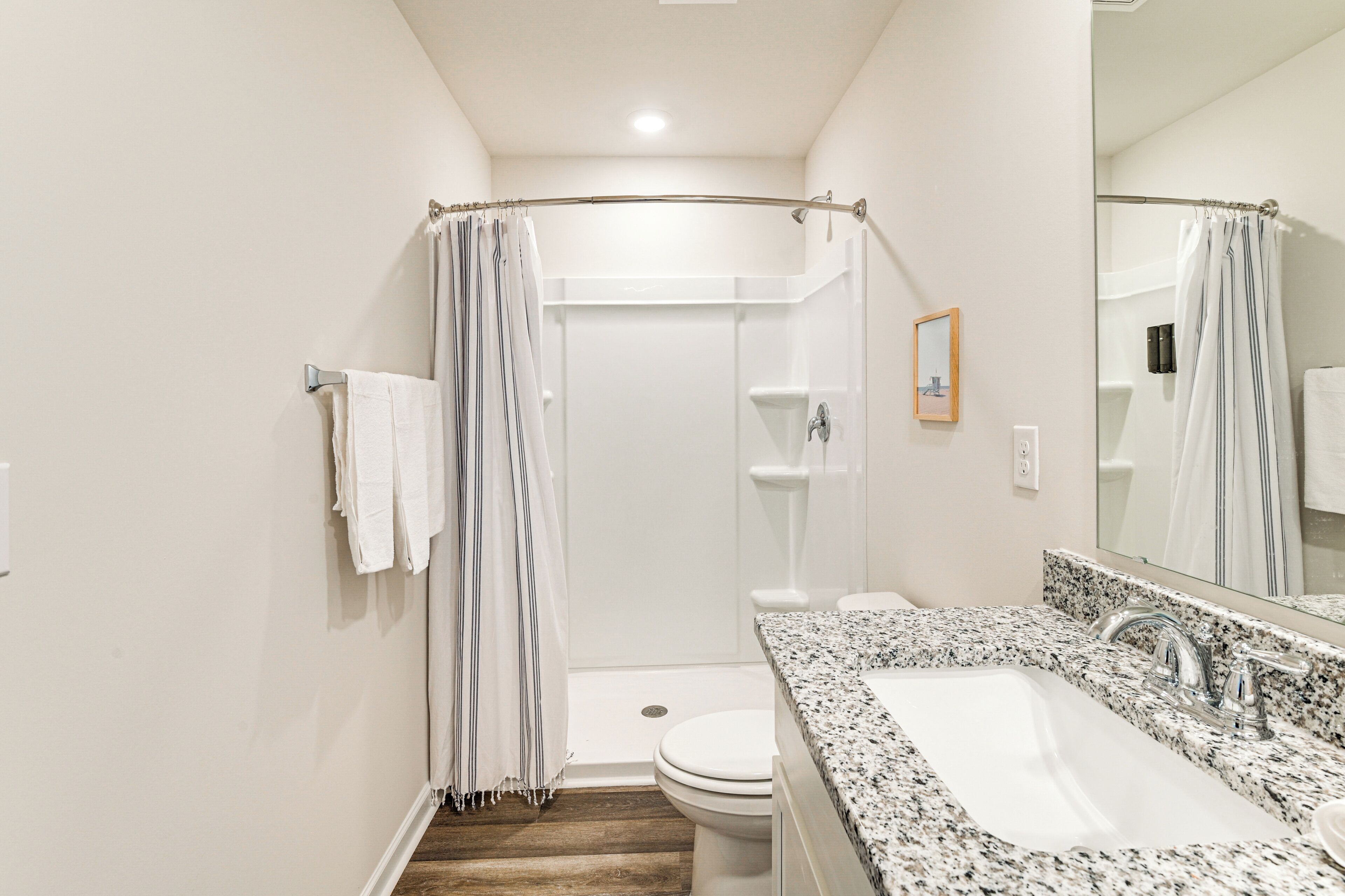 A bathroom with a shower, toilet, and sink.