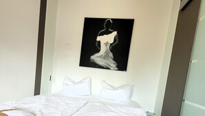 A hotel room with a bed, white bedding, a painting of a woman on the wall, and a window with blinds. - Apartment in Winterberg Near Ski Lifts (Winterberg)
