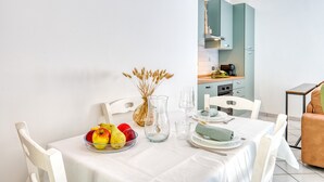 A dining area with a table set for two, a pitcher, a bowl of fruit, and a vase with dried flowers. - Umbria Casa Vacanze – Panoramic Views & Relaxation Near Marmore Falls (Montefranco)