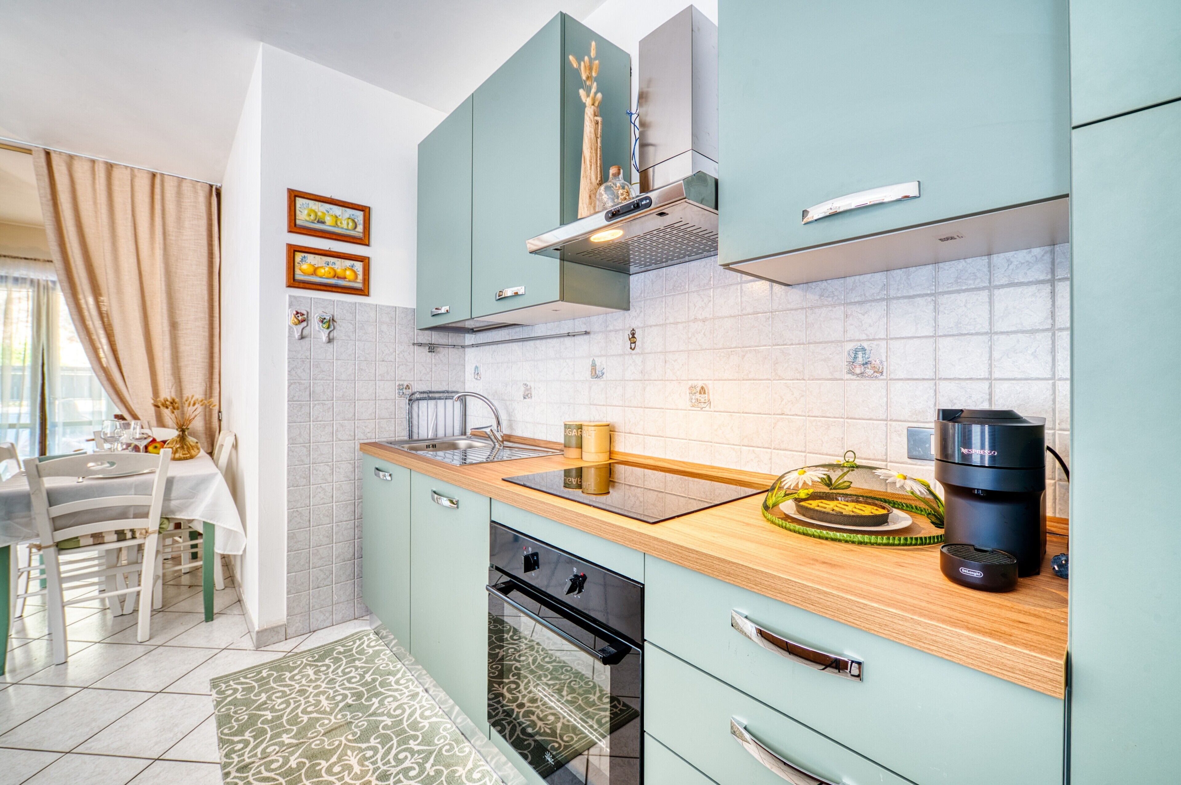 A modern kitchen with a wooden countertop, a built-in oven, and a coffee maker.