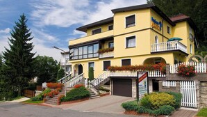 Un hôtel à plusieurs étages, doté d’une façade jaune, de balcons et d’une entrée fermée par un portail.