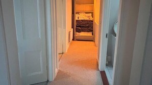A narrow hallway with carpeted floors and white doors on both sides. - City Victorian Townhouse Cork, Kennedy Park (Cork)