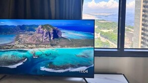 Televisiossa näkyy kaunis maisema rannikolta, jossa on jyrkkiä kallioita ja turkoosinsinisiä vesiä.