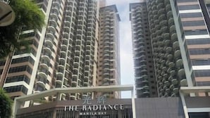 Korkea kerrostalo, jossa on parvekkeet ja kyltti, jossa lukee: ”The Radiance Manila Bay”.