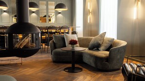 Una sala de estar moderna con chimenea, un sofá, una mesa de centro y un comedor al fondo.