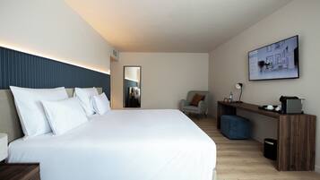 Een moderne hotelkamer met een groot bed, een bureau, een stoel en een groot raam.