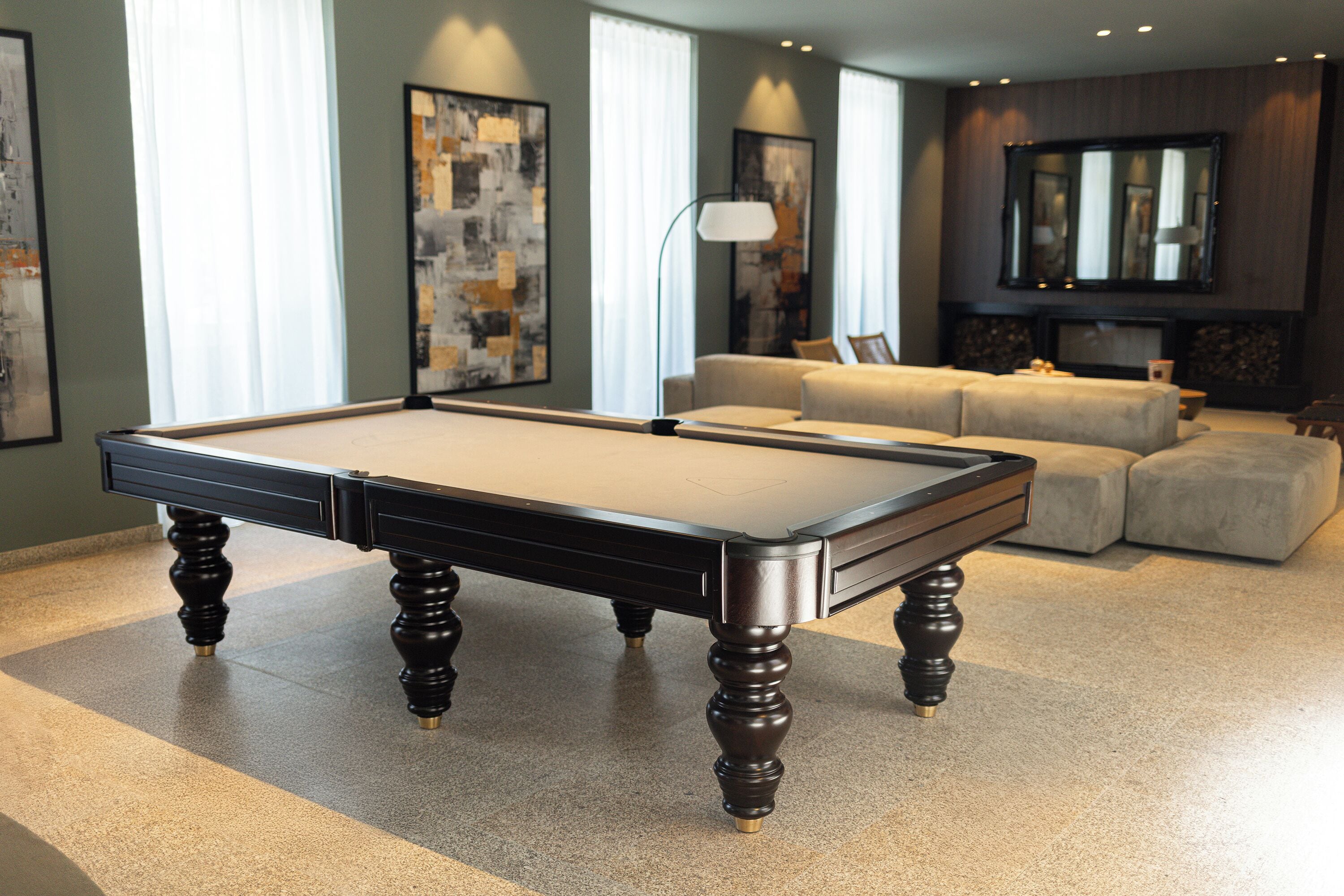A pool table in a room with a sofa and a fireplace.