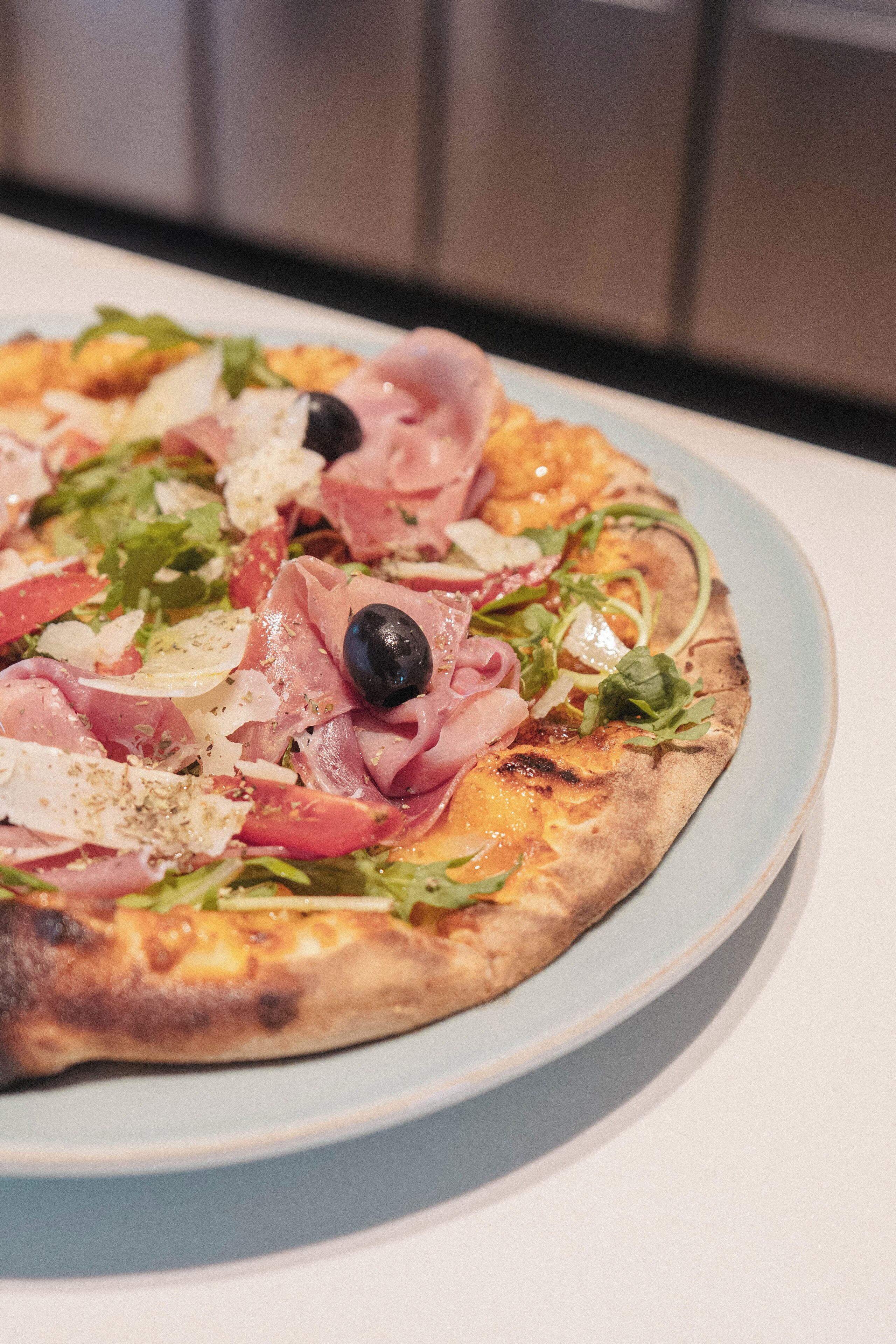 Una pizza con diferentes ingredientes servida en un plato.