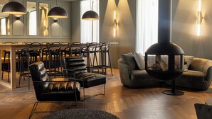 Una sala de estar moderna con sillones de cuero, una mesa redonda y una estufa de leña.