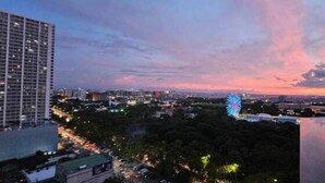 Une vue sur une ville au crépuscule, avec une grande roue bien visible et de nombreux immeubles de grande hauteur.