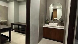 Une salle de bain moderne avec un grand miroir, un lavabo et un meuble-lavabo.