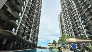 A swimming pool surrounded by high-rise residential buildings with balconies. - 10G The Sunset Executive @ The Radiance Manila Bay (Pasay City)