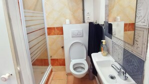 A bathroom with a toilet, sink, and shower area. - Historic center apartment close to the lively and dynamic hyper center. (Unknown)