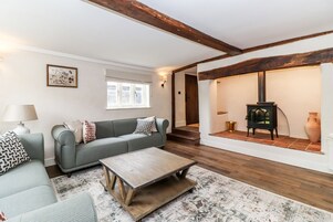 A cozy living room with a sofa, a coffee table, and a fireplace.