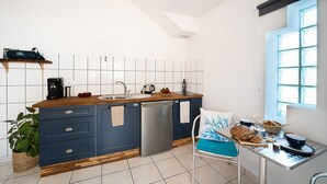 A modern kitchen with a dishwasher, wooden countertop, and a window with a view. - Sable entre les Orteils - Studio vue mer (Banyuls-sur-Mer)