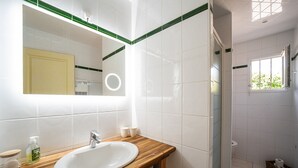 A bathroom with a wooden vanity, white sink, and a mirror. - Sable entre les Orteils - Studio vue mer (Banyuls-sur-Mer)