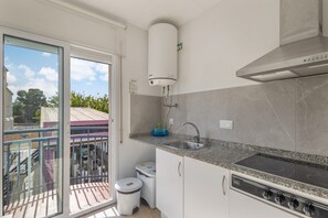 A modern kitchen with a built-in stove, a sink, and a water heater.