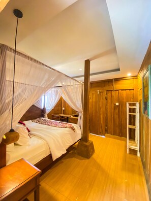 A room with a bed under a canopy, wooden walls, a wooden floor, and a ladder against the wall. - Joglo Breeze Guest House and Villa Room 2 (Bali)