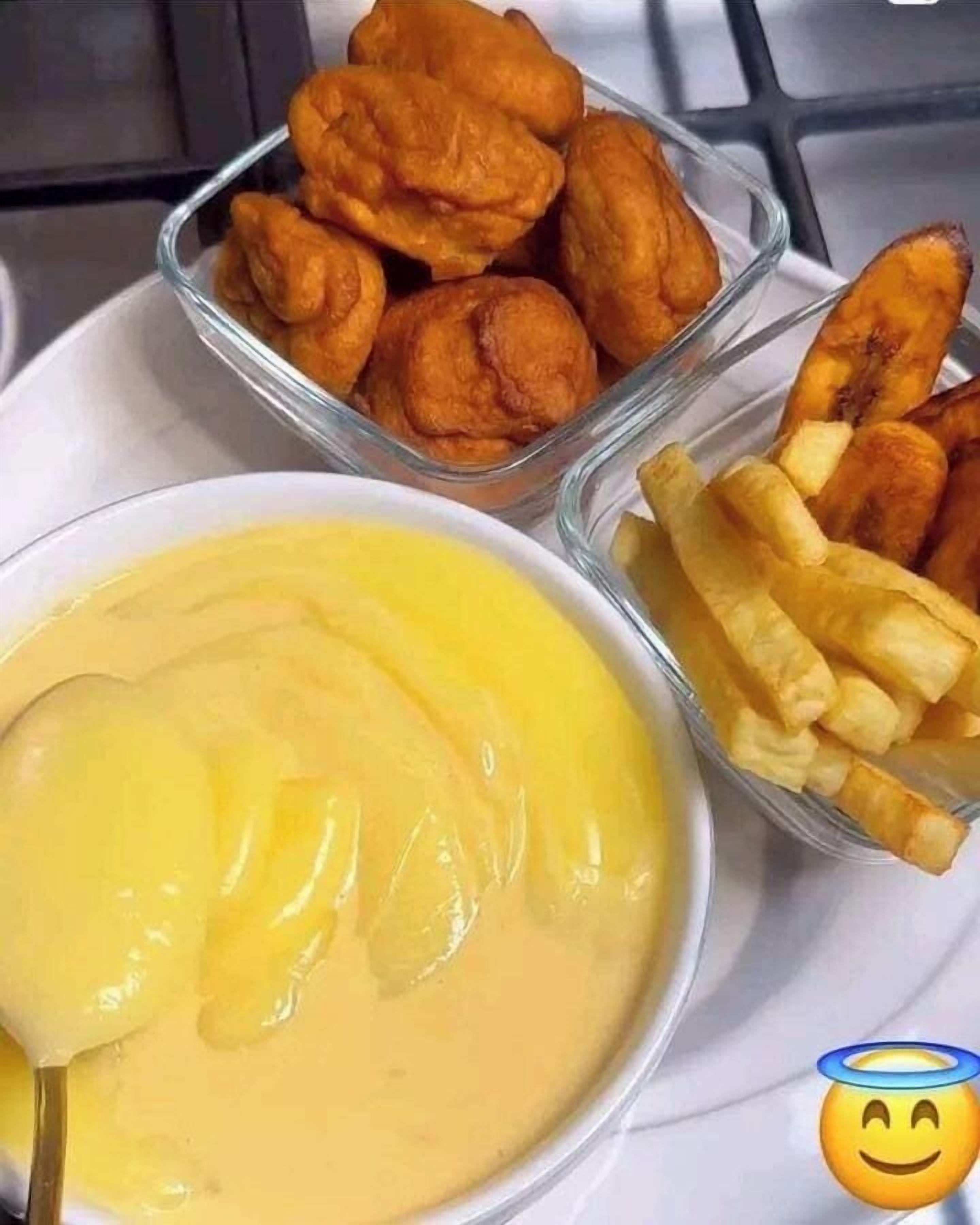 A plate with three containers of food: a bowl of yellow sauce, a bowl of fried items, and a bowl of fries.