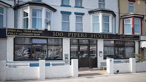 A hotel with a sign reading '100 Pipers Hotel' and 'Open All Year Round Fully Licensed Bar'. - 100 Pipers Hotel (Blackpool)