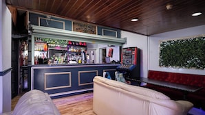 Un espace bar comprenant un comptoir, des tabourets de bar et un canapé.