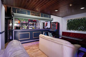 A bar area with a counter, bar stools, and a sofa.