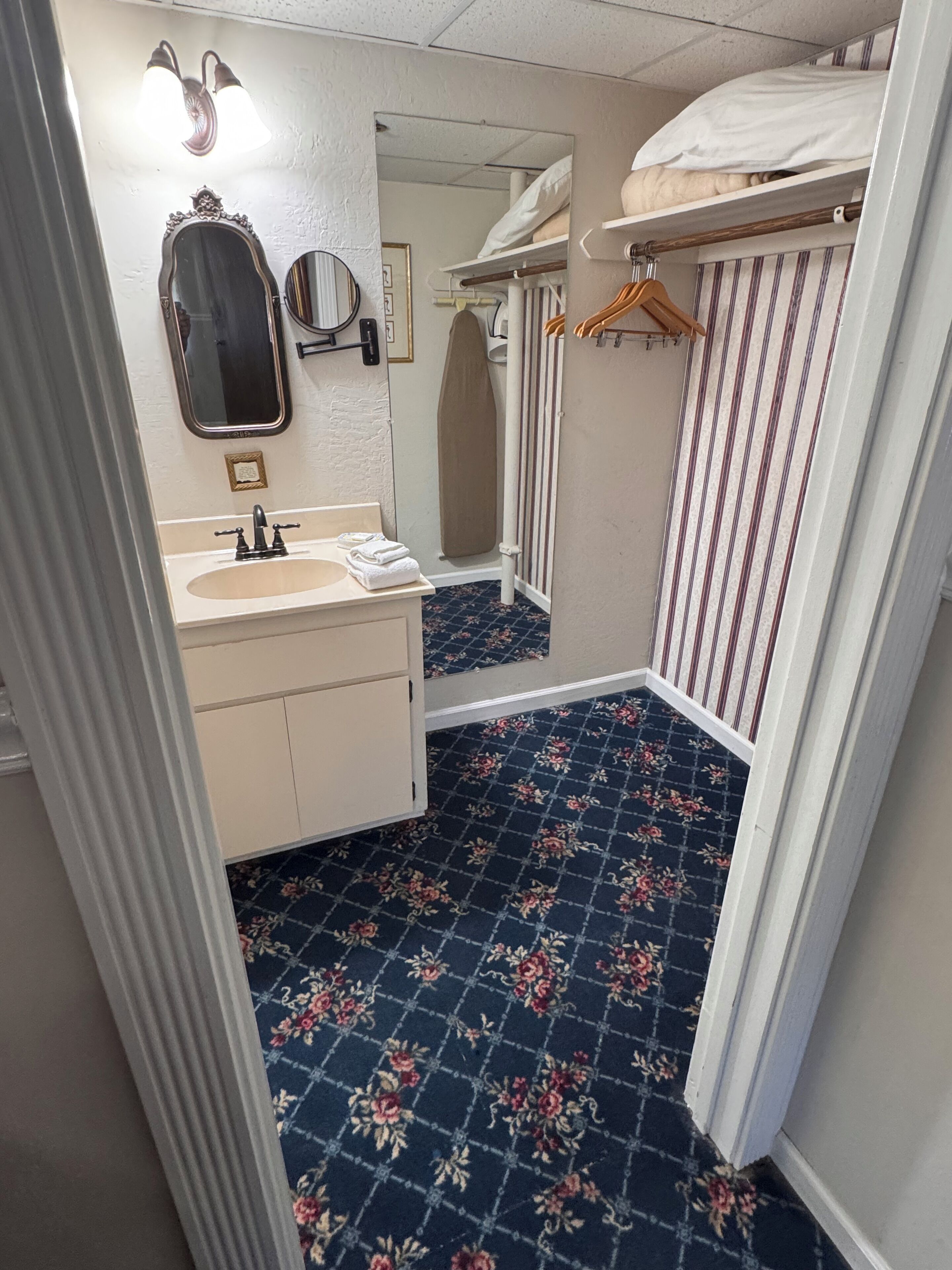 A bathroom with a sink, mirror, and a shower area.