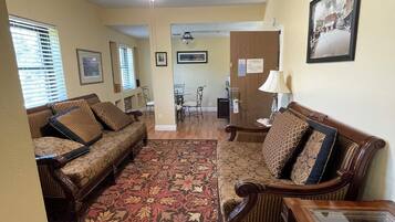 A living room with a patterned rug, two sofas, a coffee table, and a ceiling fan.