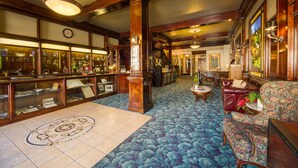 A lobby with a patterned carpet, wooden furniture, and display cases. - Boutique Retreat in Wine & Gold Country (Placerville)