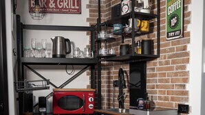 Een kleine keuken met een rode koelkast, een magnetron en een koffiezetapparaat.
