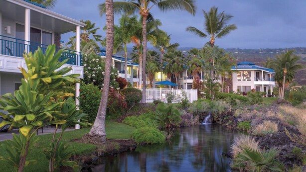 A resort with multiple buildings, a small waterfall, and lush tropical vegetation. - Stay in paradise minutes from the beach (Kailua Kona, Island of Hawaii)