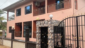 A two-story building with a balcony, a gated entrance, and a decorative gate.