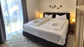 A hotel room with a large bed, two bedside tables, a window with curtains, and a wall-mounted bird decoration. - Spacious Winterberg Stay for 7 Guests (Winterberg)