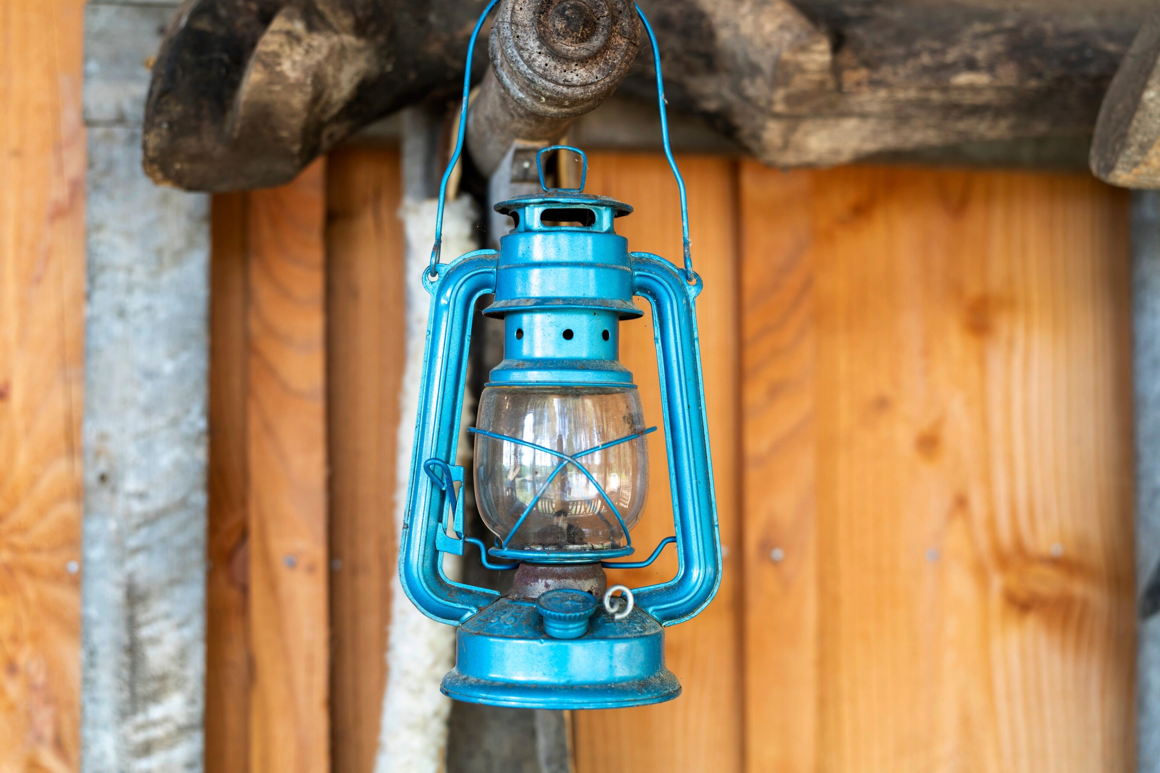 Une lanterne bleue suspendue à une structure en bois.