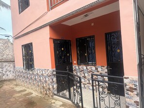 A two-story building with a tiled entrance and black decorative gates. - Yavanie Residence: 2-bedroom apartment, 2 bathrooms, 1 living room, 1 kitchen,  (Kribi)