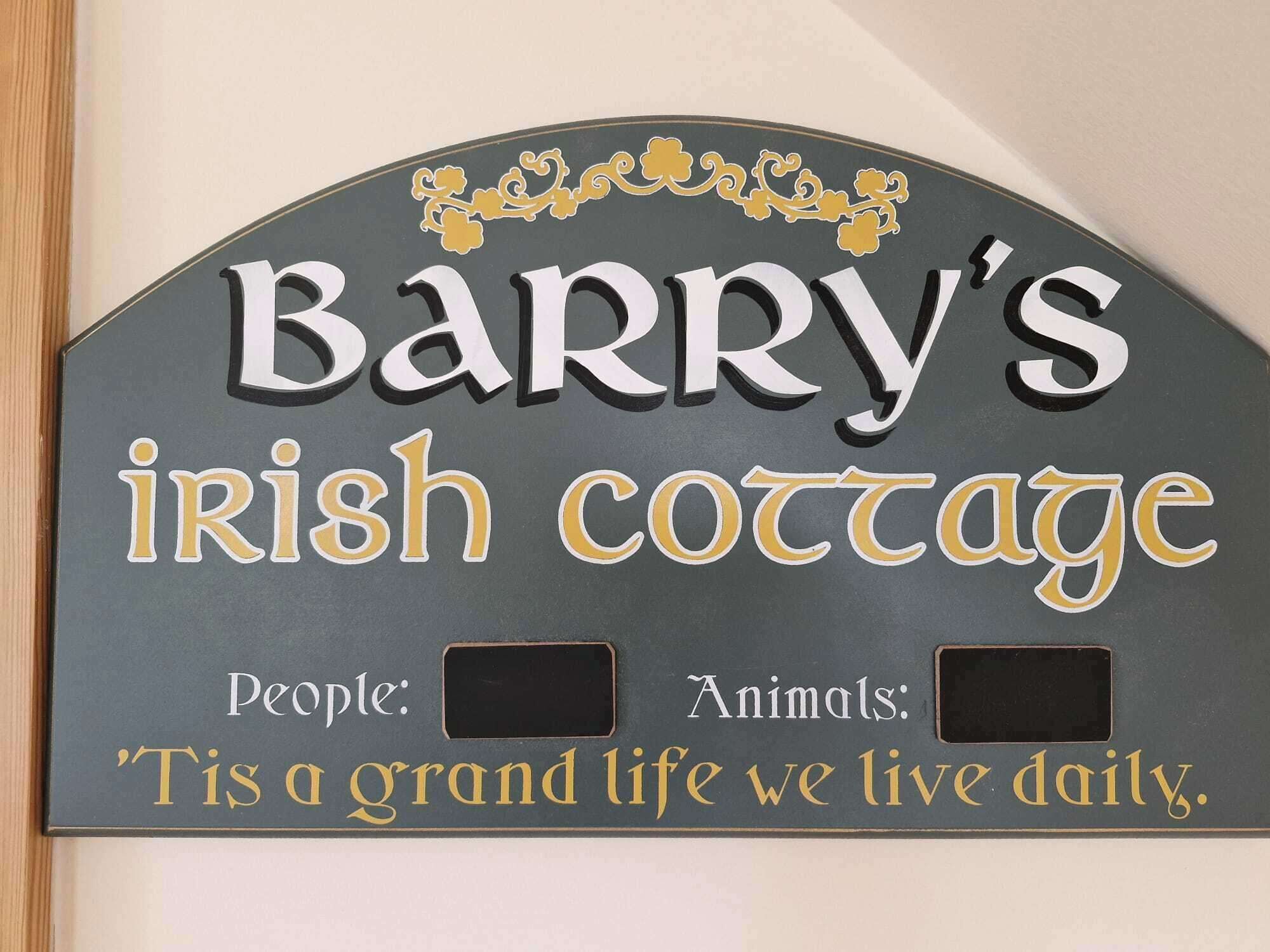 A sign for Barry's Irish Cottage with placeholders for people and animals.