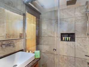 A modern bathroom with a large mirror, a white sink, and a shower area. - Hotel Central Park (Srinagar)