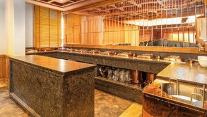 A kitchen with a granite countertop, stainless steel appliances, and wooden ceiling beams. - Hotel Central Park (Srinagar)