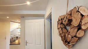 A hallway with a white door leading to a dining area. A wall-mounted log wreath is visible. - Apartment in Winterberg Near Ski Lift (Winterberg)